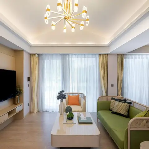 Living room with a rattan-backed olive green sofa and matching armchair, a floating wood TV console wall, a gold sputnik chandelier