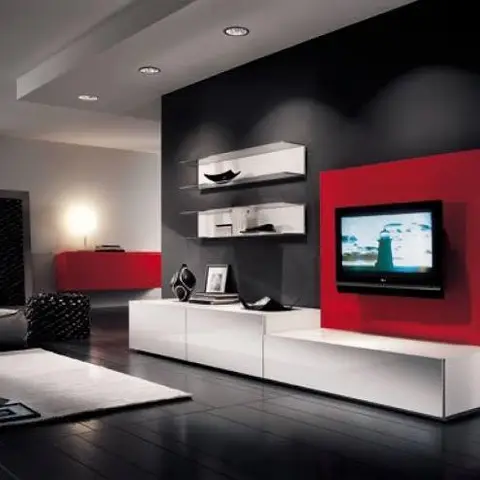 Living room with a red lacquer TV backpanel against a black accent wall, white floating console and dark wood flooring.