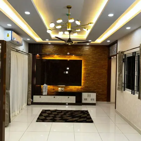 Living room with a stacked-stone-clad TV feature wall lit from behind, a gold sputnik chandelier in a cove-lit ceiling