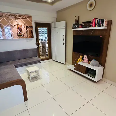 Living room with a stepped POP false ceiling, a diamond-pattern mirror wall panel