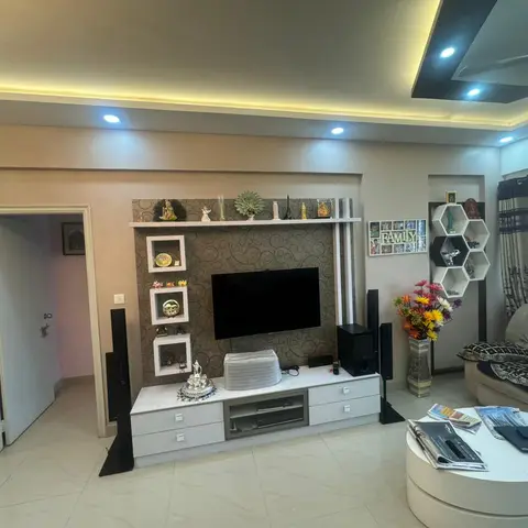 Living room with a textured-wallpaper TV feature wall flanked by floor speakers, a hexagonal display shelf