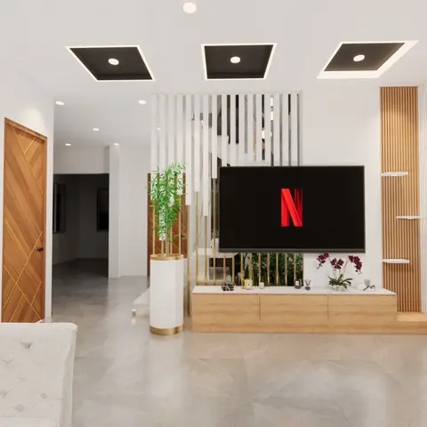 Living room with a wall-mounted TV on a floating oak console, backed by a brass-and-glass slat screen and a coffered ceiling with recessed lighting.