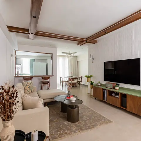 Living room with a white brick-tile TV feature wall trimmed in dark wood beams, a walnut low-profile TV console with green stone top