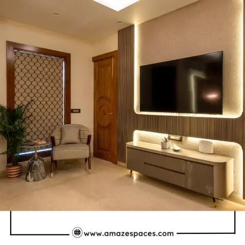 Living room with a wood-framed jaali screen beside the entrance and a backlit textured-stone TV wall over a curved gold-leg console.