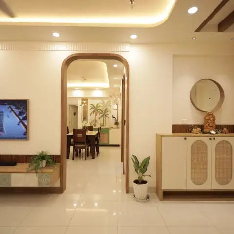 Living room with a wood-lined arched opening framing the dining table beyond, a low TV console faced with green patterned tiles
