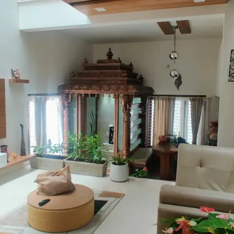 Living room with a wood-panel TV wall, cream leather sofa, round pouffe coffee table