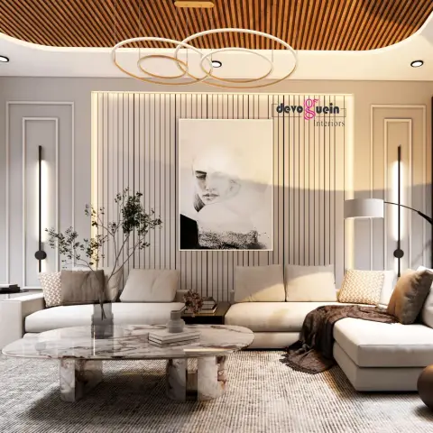 Living room with a wood-slat ceiling cove, fluted wall panelling, a ring-pendant chandelier, and an oval marble coffee table in front of a cream sectional sofa.