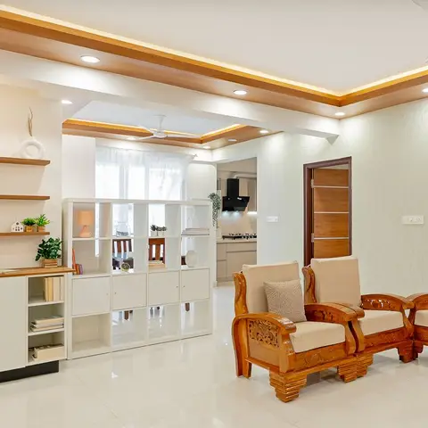 Living room with a wood-trimmed cove ceiling, a white cube-shelf room divider opening to the kitchen beyond