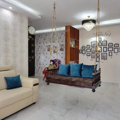 Living room with a wooden hanging swing flanked by a cream sofa, teal cushions, gold damask wallpaper and a heart-shaped photo gallery wall.