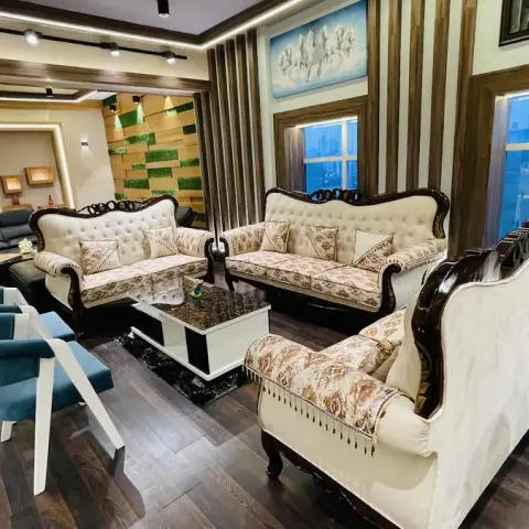Living room with carved dark-wood-frame upholstered sofas, a black-and-white marble coffee table