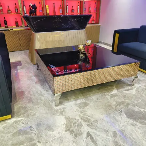Living room with channel-tufted navy velvet sofas, an ornate lift-top coffee table with a mother-of-pearl mosaic skirt