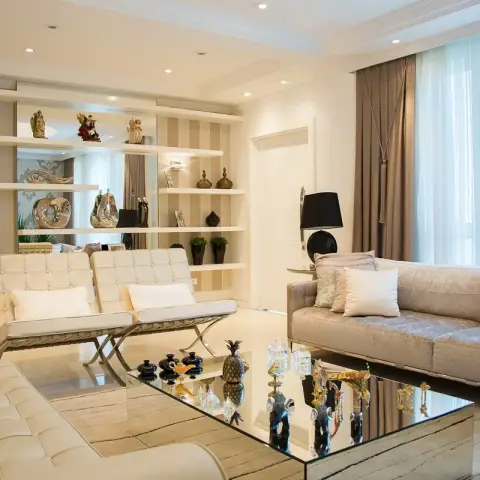 Living room with cream tufted Barcelona-style chairs around a mirrored coffee table