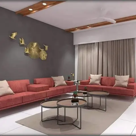 Living room with facing terracotta sofas, a dark accent wall with a brass bird wall sculpture, and nested round coffee tables on a beige rug.