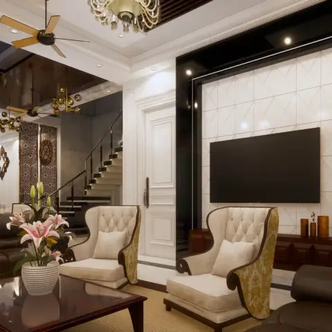 Living room with tufted wingback chairs, a diagonal-tile TV feature wall framed in black gloss, and a carved wood jaali partition screening the staircase.