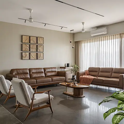 Living room with two tan leather sofas and cane-and-wood armchairs around an oval walnut coffee table