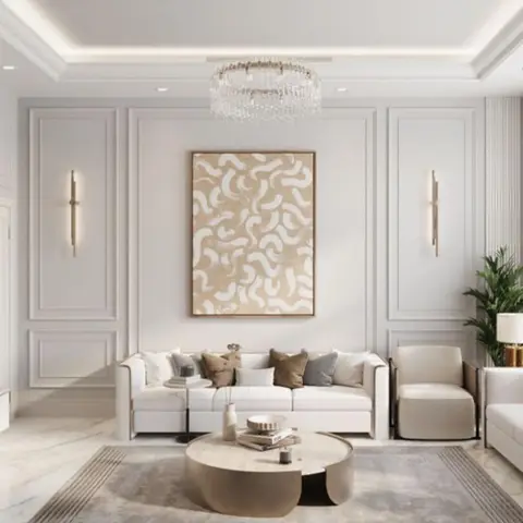 Living room with wall-panel moulding, a crystal chandelier, and a white sofa arranged around a round two-tier coffee table on a grey rug.