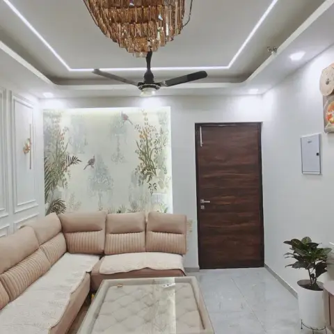 Living room with white panel-moulded walls, a botanical bird-print wallpaper accent, a crystal chandelier over the ceiling fan