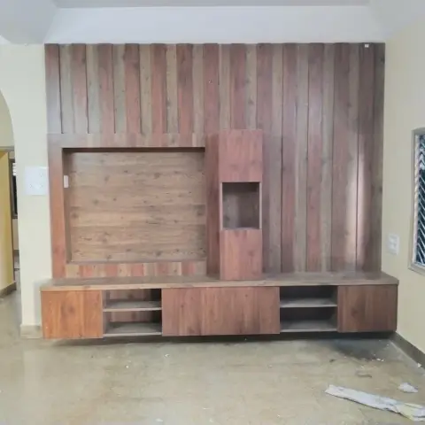 Living room wood-panelled TV feature wall with vertical fluted wood slats and an open display niche