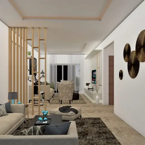 Long living room split by a slatted wood partition into two beige seating areas, with a wall-mounted TV console and a cluster of circular bronze wall discs on