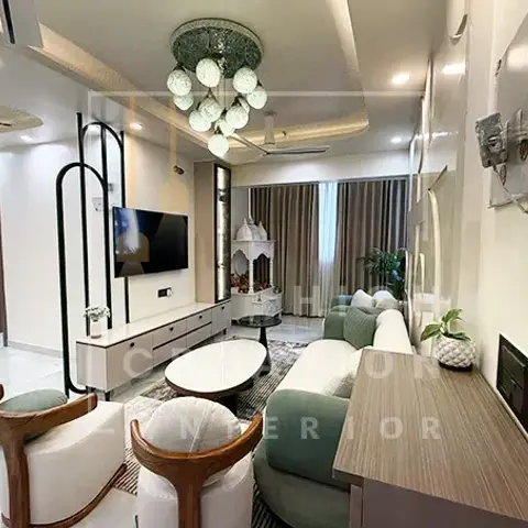 Long narrow living room where a sage-green sofa and two wood-framed tub chairs sit around white round nesting tables