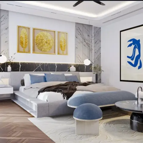 Low grey platform bed under a black-marble headboard ledge with a concealed light strip, a gold triptych of leaf and starburst art above it