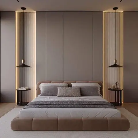 Low platform bed with a tufted upholstered base centered between two backlit fluted-wood panel columns and matching pendant lights