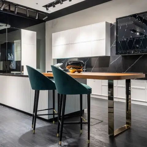 Luxury kitchen island with a dramatic black-and-white marble backsplash wall, fluted white cabinetry