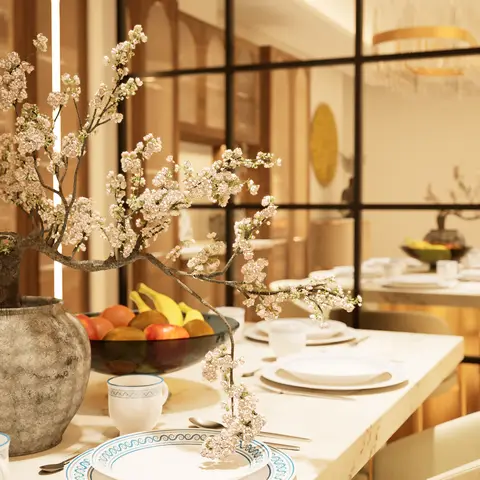Marble dining table set with blue-and-white china and a large cherry-blossom branch centerpiece