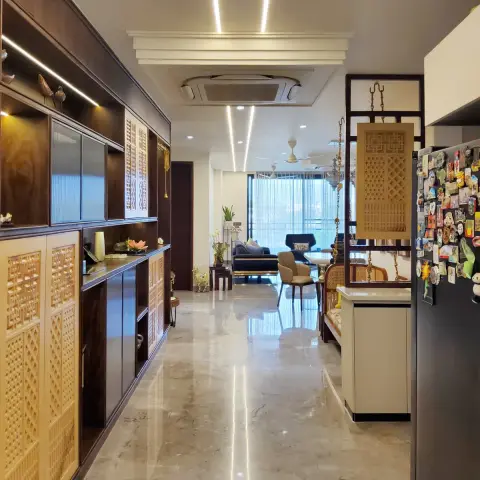 Marble-floored entrance passage lined with dark wood cabinetry featuring carved jaali panel doors