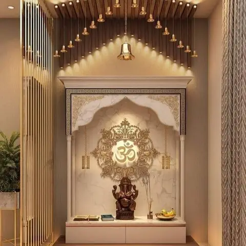 Marble pooja unit with an arched gold Om motif backdrop, hanging temple bells under a fluted wood pelmet, and a Ganesha idol on the platform.