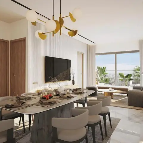 Marble-top dining table with grey upholstered chairs beneath a brass sputnik-style pendant, open to a living lounge with a city view beyond.