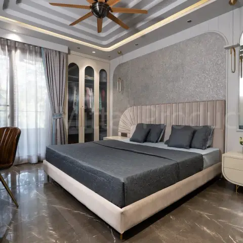 Master bedroom where a cream channel-tufted headboard opens into a fan-pleated panel against silver textured plaster