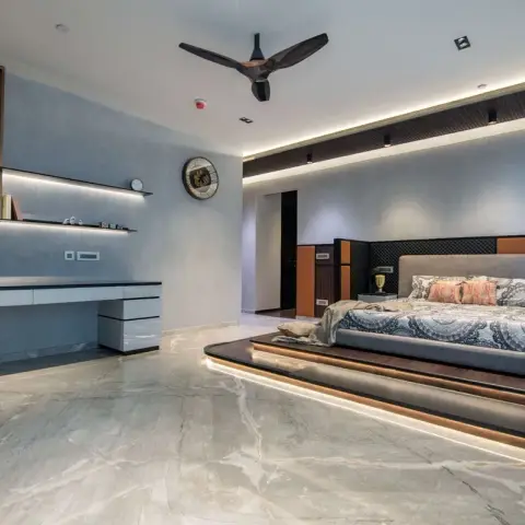 Master bedroom where the bed stands on a curved timber platform with an LED strip under its nosing, against a headboard wall mixing dark fluting