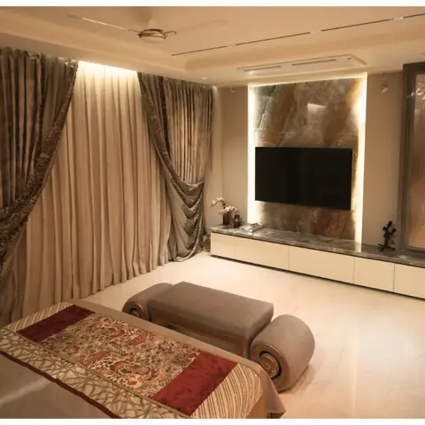 Master bedroom with a backlit natural-stone slab TV feature wall, a marble-clad floating console, a mirrored backlit display cabinet