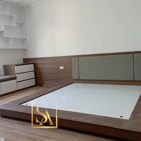 Master bedroom with a built-in low platform bed featuring a sage-green channel-tufted headboard against a wood-panelled wall