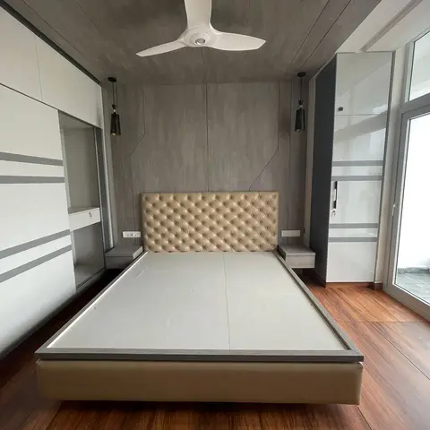 Master bedroom with a champagne tufted-leather bed and integrated grey floating nightstands under a geometric wood-panelled headboard wall