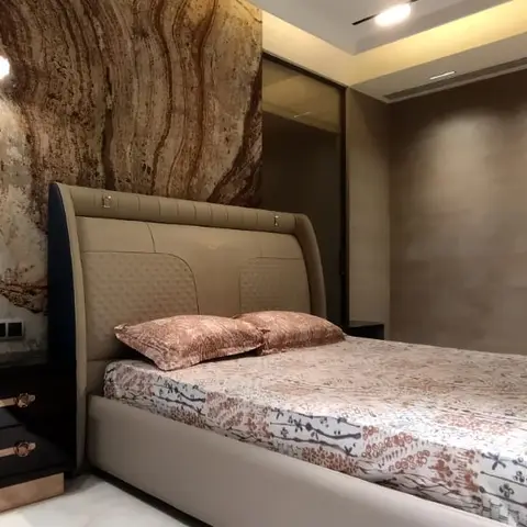 Master bedroom with a dramatic book-matched marble slab feature wall lit by pendant lights