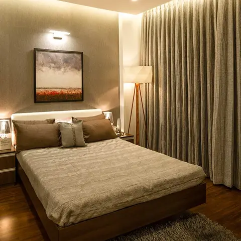 Master bedroom with a floating platform bed under an LED-lit headboard, a framed landscape above, and full-height woven curtains along the window wall.