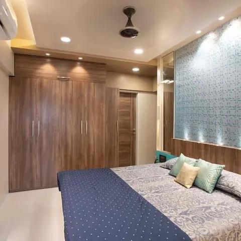 Master bedroom with a floor-to-ceiling wood wardrobe, a teal patterned wallpaper headboard wall with accent uplighting, and a built-in TV display niche.