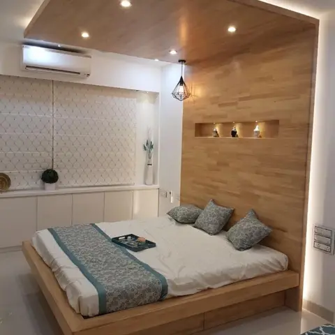 Master bedroom with a floor-to-ceiling light-wood panelled headboard wall that wraps onto the ceiling over a floating wood platform bed