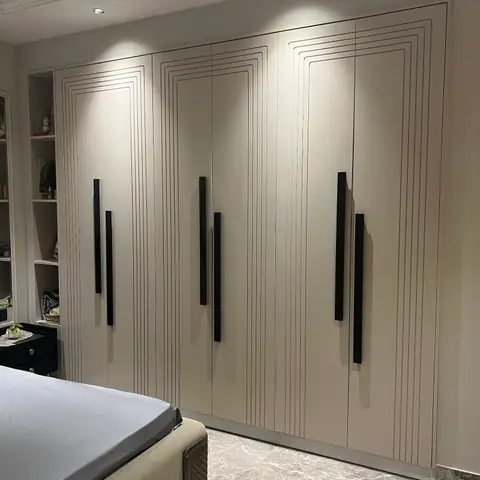 Master bedroom with a floor-to-ceiling six-door wardrobe wall featuring concentric groove detailing and long black bar handles