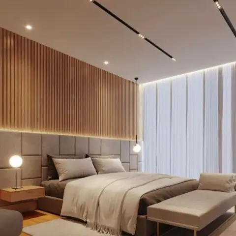 Master bedroom with a full-height fluted wood-slat accent wall above a grey channel-tufted upholstered headboard, sheer floor-to-ceiling curtains