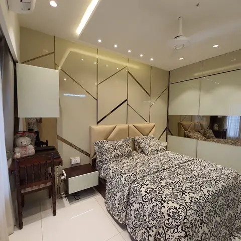 Master bedroom with a geometric mirrored gold-line accent wall behind the bed and a full mirrored sliding wardrobe.