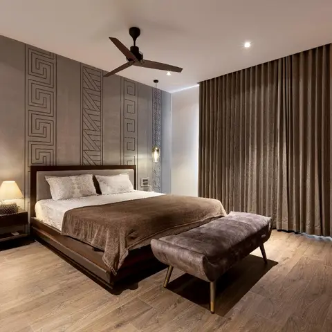 Master bedroom with a grey headboard wall carved into vertical bands of geometric fretwork, a low dark-wood bed