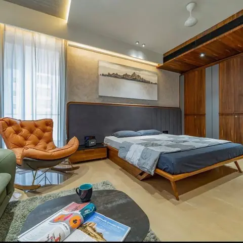 Master bedroom with a mid-century wood bed frame and grey channel-tufted headboard, a tan leather tufted rocking chair