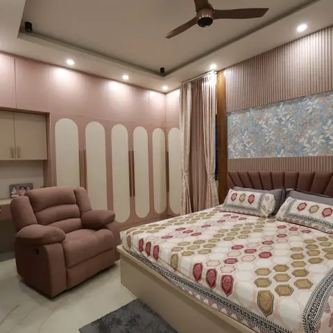 Master bedroom with a scalloped mauve upholstered headboard against a fluted-panel and floral-wallpaper wall, a rose-pink arched wardrobe run