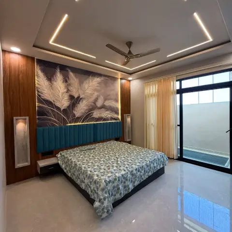 Master bedroom with a teal channel-tufted headboard beneath a backlit feather-mural wall panel, framed by a diamond-shaped cove-lit ceiling.