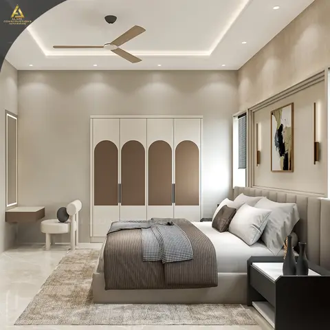 Master bedroom with an arch-panel white and taupe wardrobe, a wall-mounted dressing nook, abstract framed art between brass wall sconces