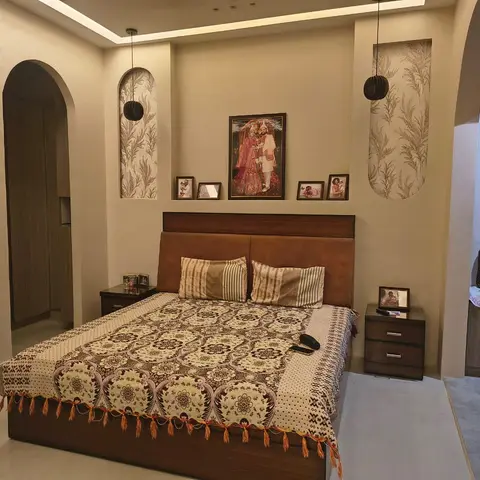 Master bedroom with an arched wall niche framing a wedding portrait and family photos above a tan leather headboard