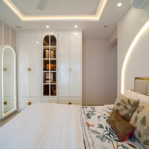 Master bedroom with an arched white wardrobe featuring a glass display door for designer bags, a backlit full-length arch mirror